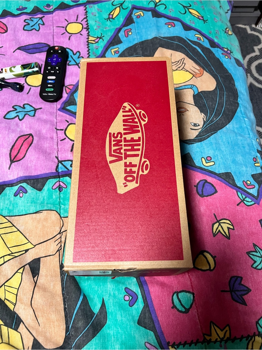 Vans shoebox on colorful bedspread